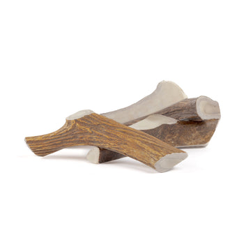 four jumbo moose split antler chews in a pile on a white background