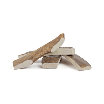 four large moose paddles in a pile on a white background