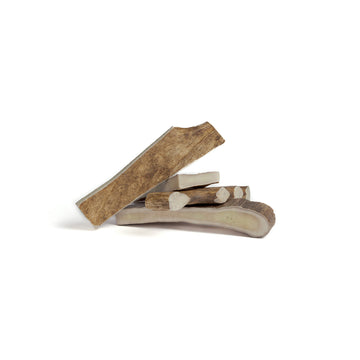 four medium moose paddle antler chews in a pile on a white background