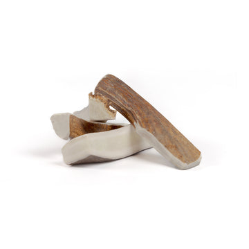 four medium moose split antler chews in a pile on a white background