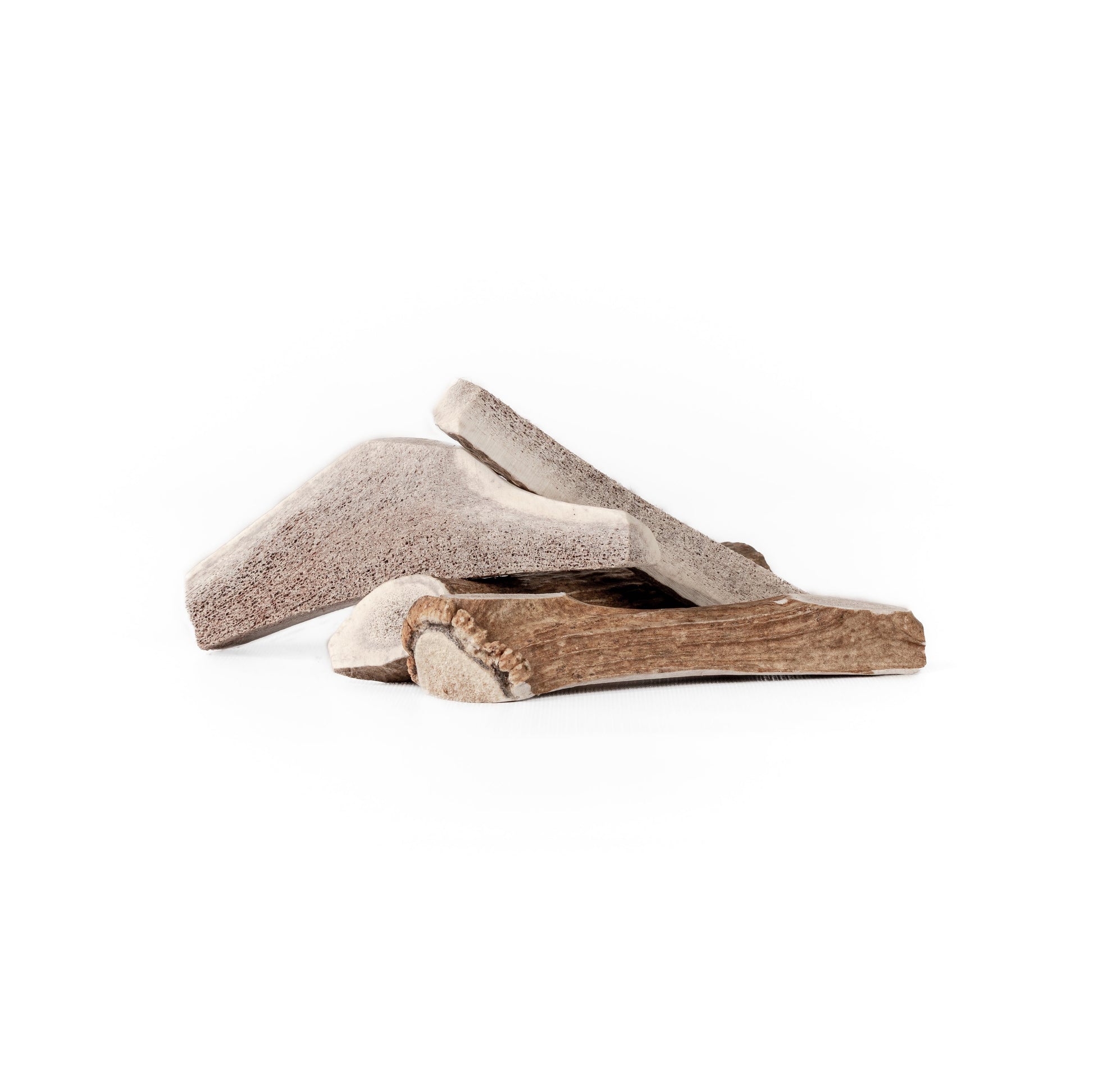 four medium split and quarter split elk antlers in a pile on a white background