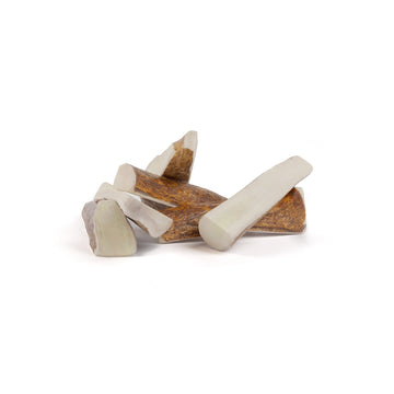 six small moose split antler chews in a pile on a white background